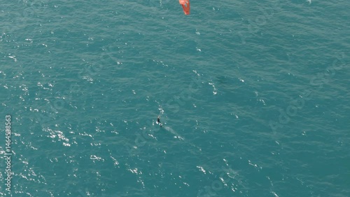 Summer Thrill: Man Kitesurfing in Clear Blue Sea from Above. Kite summer trip