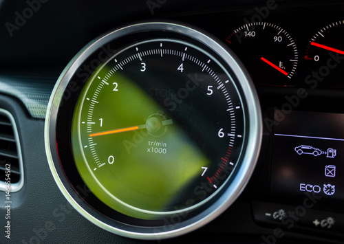 Close-up of car tachometer showing engine idle speed and eco mode photo