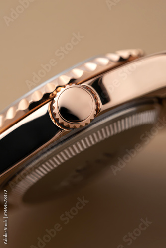 Obraz na płótnie A close-up view highlights the detailed features of a luxury wristwatch with a shiny rose gold case, focusing on the crown and textured bezel against a soft background w salonie