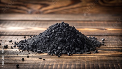 Dark gray coal powder scattered on wooden table , coal residue, dark gray powder
