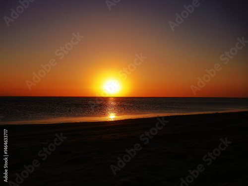 Dull sundown, stuffy air. Sunset over the saltpan lake after a sultry day, dull orange light due to the high humidity
