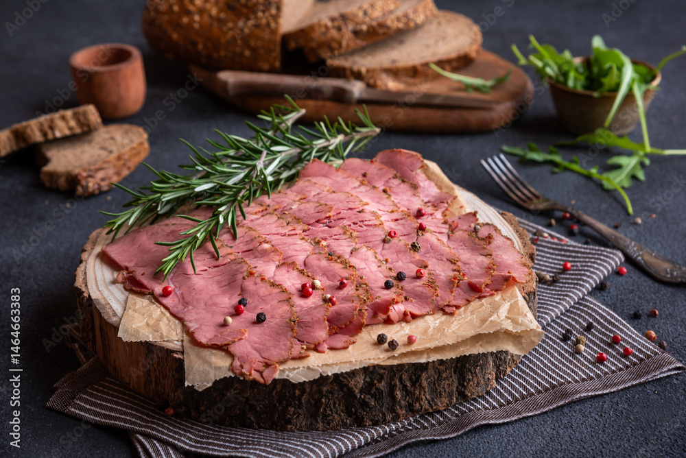 Sliced pastrami meat with rosemary and pepper Sliced pastrami meat with rosemary and pepper