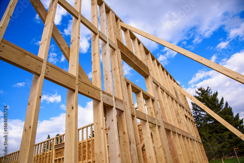 Low angle view of framed wall braced into place for new wood frame commercial building under construction,