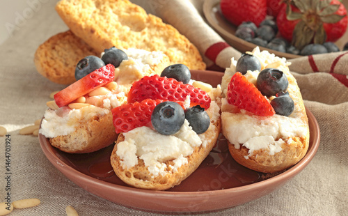 Crostini with ricotta, berries, pine nuts. Slices of toasted bread with cheese for breakfast. A healthy meal and snack.