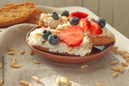Crostini with ricotta, berries, pine nuts. Slices of toasted bread with cheese for breakfast. A healthy meal and snack.