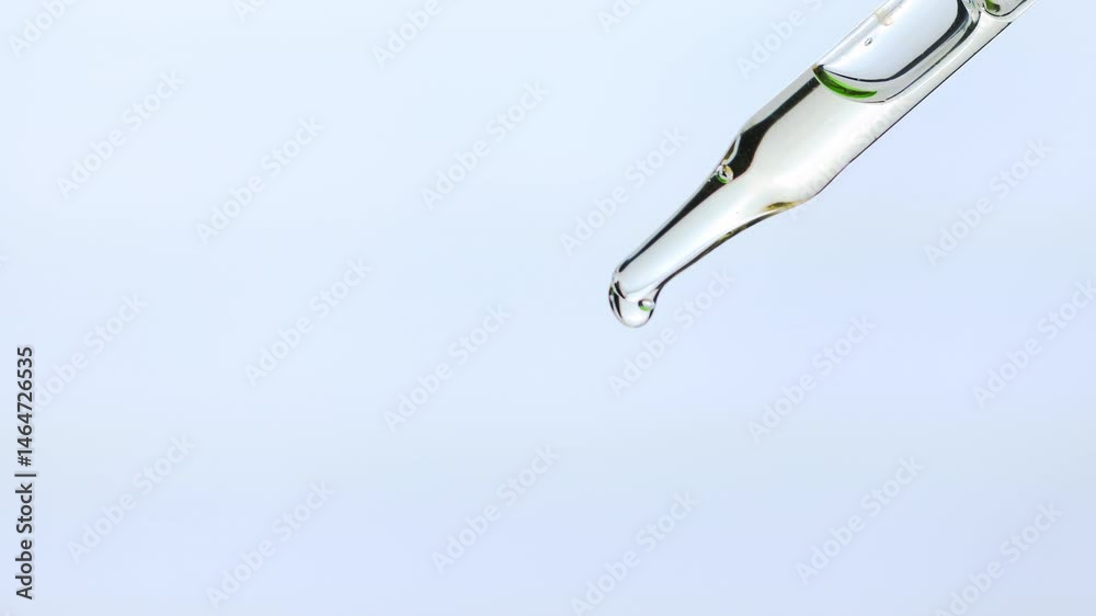 Close-up of clear of Essential oil , Serum droplet falling from a glass dropper on a white background. Perfect for skincare, wellness, or scientific themes etc.,  4K video