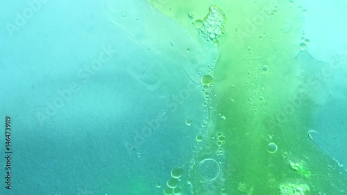 Oil and water drops on blue green background. 4K video.