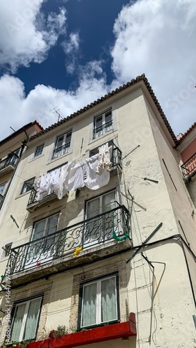 Freshly laundered linens sway in the sun, evoking the charm of traditional Festa dos Tabuleiros, urban balconies alive photo