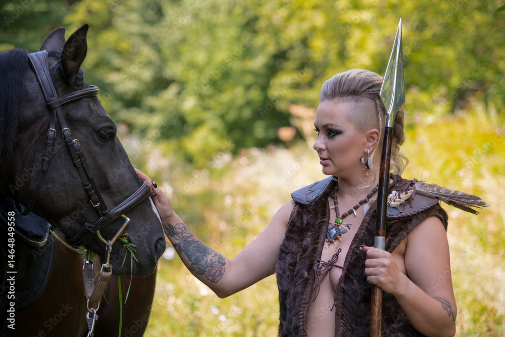 Obraz premium Warrior interacts with horse in natural setting during sunny afternoon