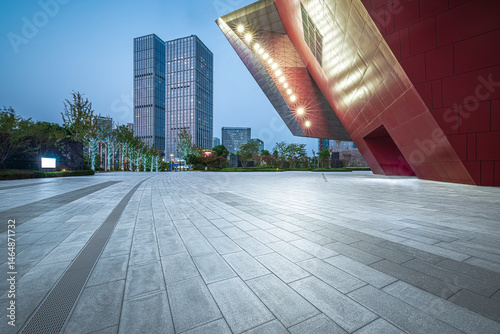 Fototapeta Naklejka Na Ścianę i Meble -  Empty public square and modern office building in the city financial district at dusk. Urban architecture and business background.