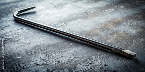Close-up view of a metallic pry bar resting on a textured surface