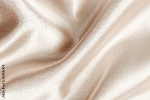 Soft beige satin fabric draped elegantly showcasing its smooth texture and sheen