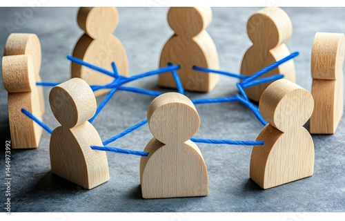 Wooden figures connected by blue strings, forming a circle.  Diverse group.  Symbolic of collaboration and connection