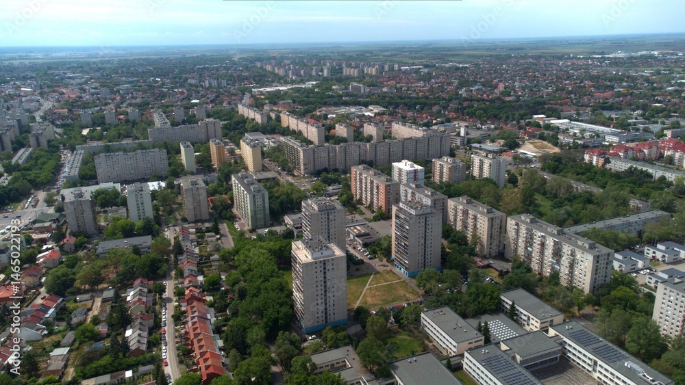 Fototapeta premium Aerial cityscape, Debrecen, Hungary. Urban skyline, modern highrise panel flats and apartment complexes. Residential blocks, roads, rooftops, and greenery. Eastern and Central European city. Block of 