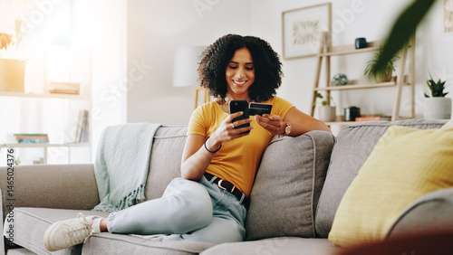 Credit card, happy and woman on sofa with phone for online shopping, web store sale and purchase. Home, relax and person on smartphone for internet payment, digital order and ecommerce in living room