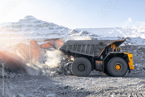Obraz na płótnie Heavy machinery operating in snowy open-pit coal mine during wintertime. Concept mining industry work w salonie