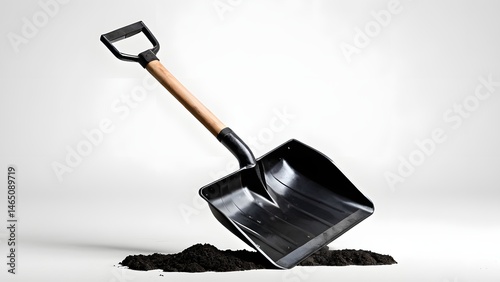 Black Shovel with Wooden Handle Resting on a Pile of Dark Soil