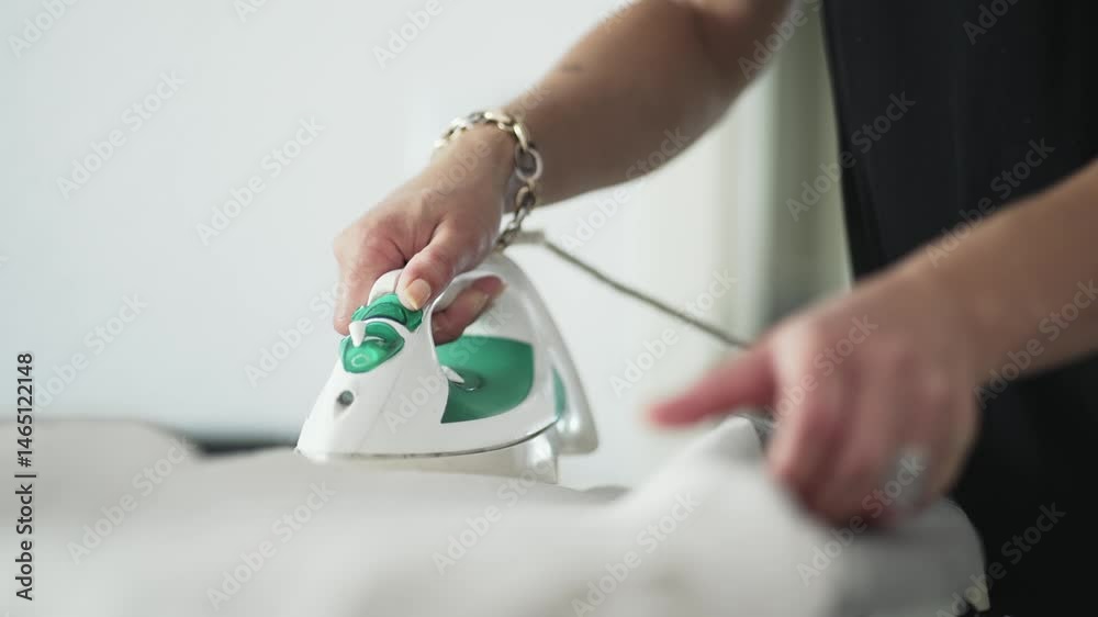 Woman ironing clothes on ironing board in slow motion