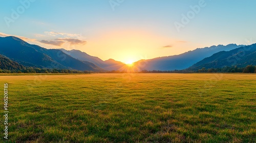 Sunset Over a Grassy Field and Mountains