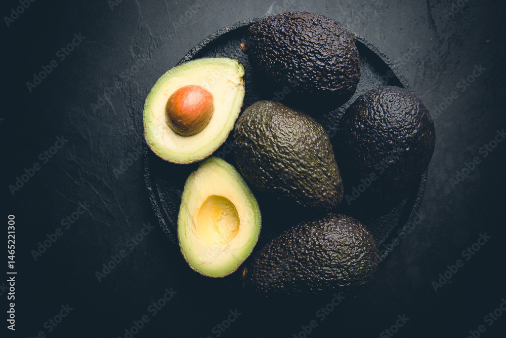 Fresh, raw avocado on a black background, top view