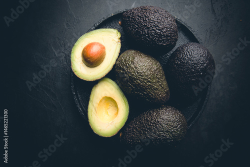 Obraz na płótnie Fresh, raw avocado on a black background, top view w salonie
