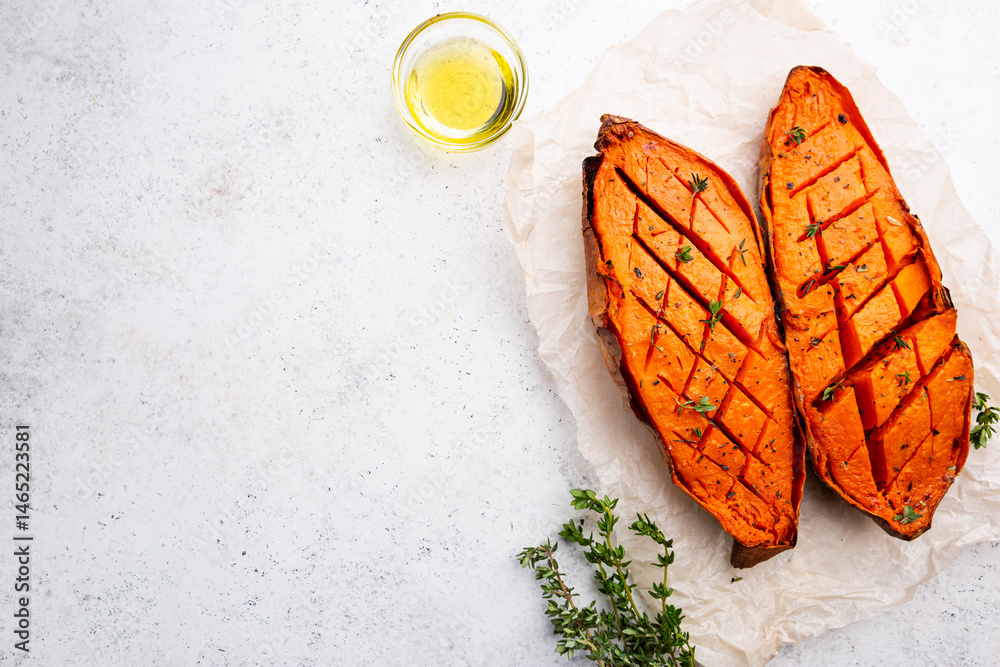 Two halves of baked yam sweet potato with spices and herbs, top view