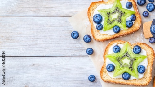 Obraz na płótnie Kiwi and Blueberry Delight: A vibrant top-down view showcases two slices of toasted bread, elegantly adorned with creamy spread, kiwi star shapes, and fresh blueberries. w salonie