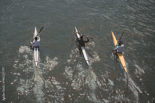 Three boys kayaking on the water, viewed from above. Active lifestyle.