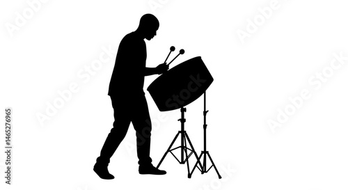 Silhouette of man playing steel drum on stand