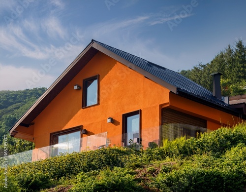 cozy orange house with a sloping roof surrounded by greenery house home cozy orange green hill sloping roof