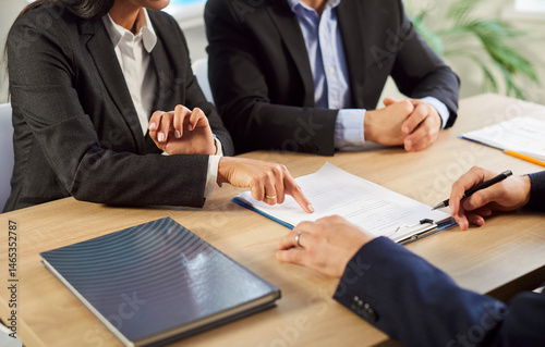 Tableau sur toile Cropped shot of two people business clients pointing fingers at a paper contract