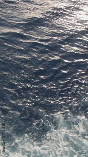 Sunlit water ripples on gentle currents, reflecting vivid blue hues and calm