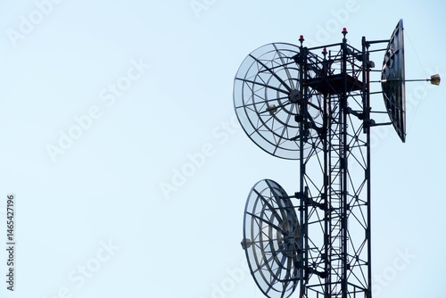 Telecommunication tower of 4G and 5G cellular. Macro Base Station. 5G radio network telecommunication equipment with radio modules and smart antennas mounted on a metal on blue sky background.