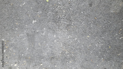 The road surface is dark grey with fallen leaves and flowers. The road surface of the parking lot has a rough texture. Texture and background images.