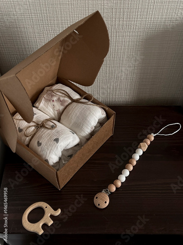 Obraz na płótnie A box of muslin diapers, beads, and a wooden elephant teether are on the bedside table. Aesthetic minimalist baby fashion w salonie