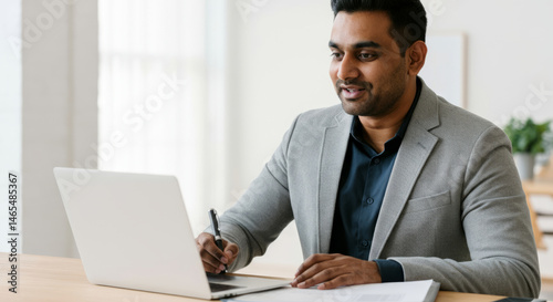 South asian adult male professional using laptop for business meeting