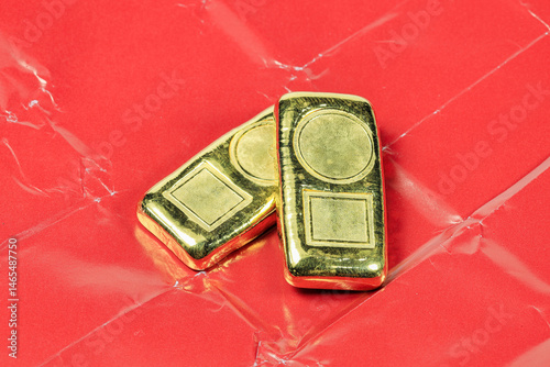 A stack of real shiny gold bars or gold ingots On the red paper used to wrap gold when trading retail in Asia.