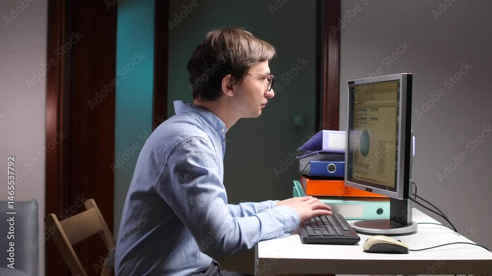 Office worker analyzing charts on computer screen at night Office worker analyzing charts on computer screen at night