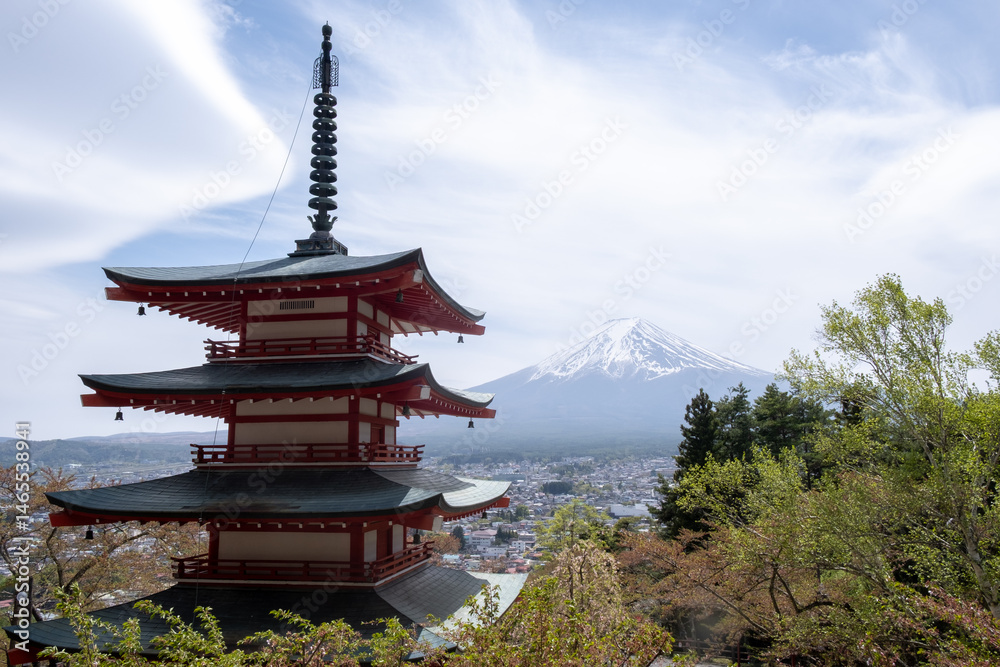 Chureito pagoda overlooking mount fuji and fujiyoshida city during cherry blossom season.