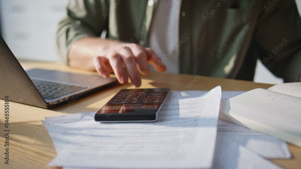 Man hand counting calculator at home office closeup. Accountant displeased