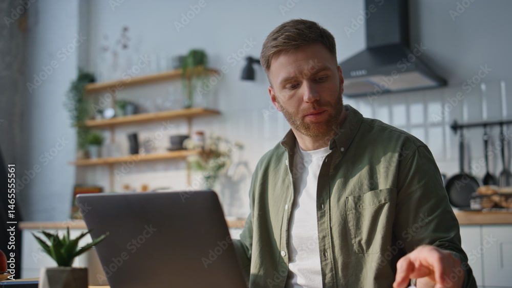 Inspired businessman working computer in home kitchen closeup. Smiling man