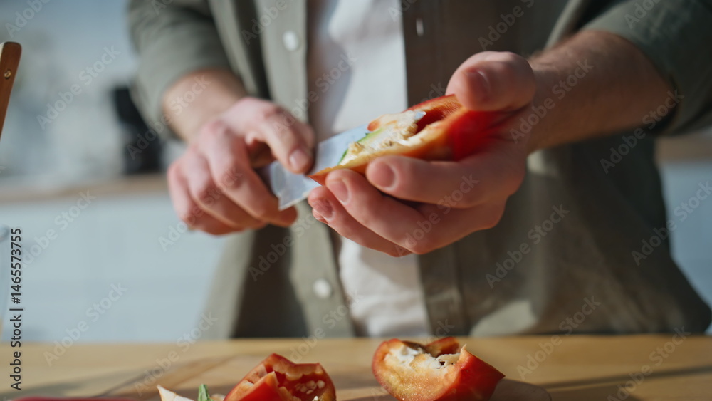 Man hands slicing pepper on kitchen closeup. Unknown guy preparing ingredients