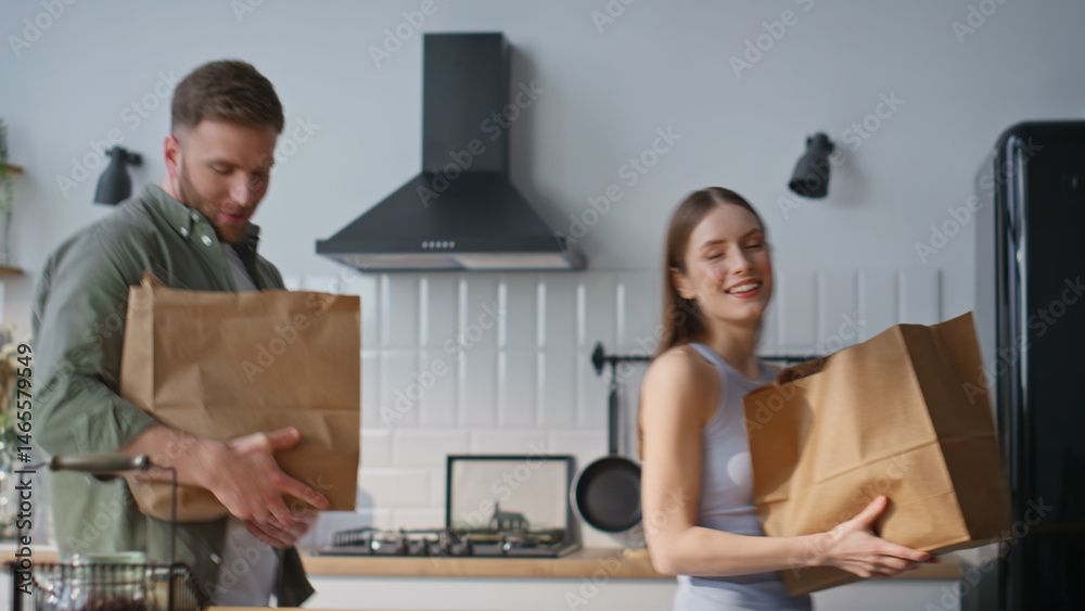 Family couple unpacking groceries in white kitchen closeup. Happy man and woman