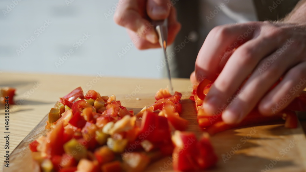 Chef hands slicing pepper on board kitchen closeup. Man chopping vegetables