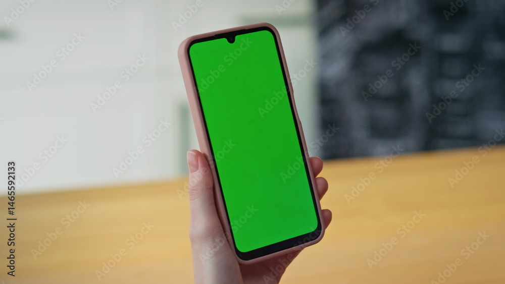 Lady hand holding chroma key cellphone at home closeup. Woman green screen phone