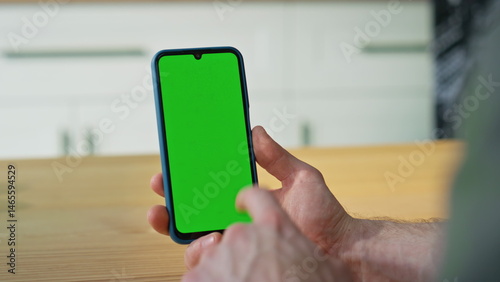 Obraz na płótnie Man scrolling chroma key mobile phone making online purchases at home closeup. w salonie