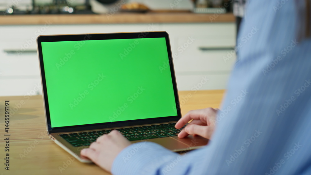 Freelancer typing greenscreen laptop at home office closeup. Unknown woman hands
