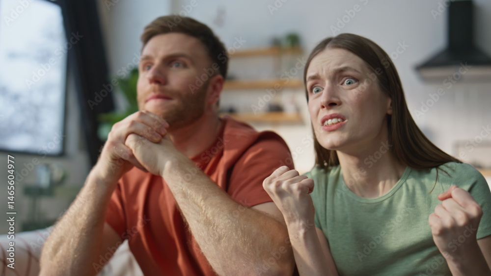 Emotional couple cheering sport game at home sofa closeup. Tensed husband wife