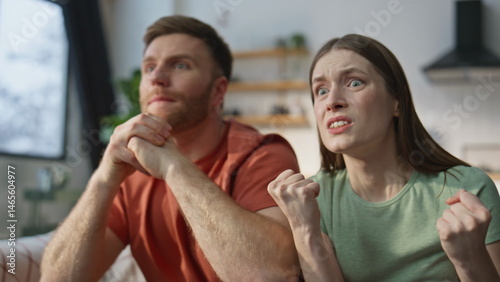 Obraz na płótnie Emotional couple cheering sport game at home sofa closeup. Tensed husband wife w salonie
