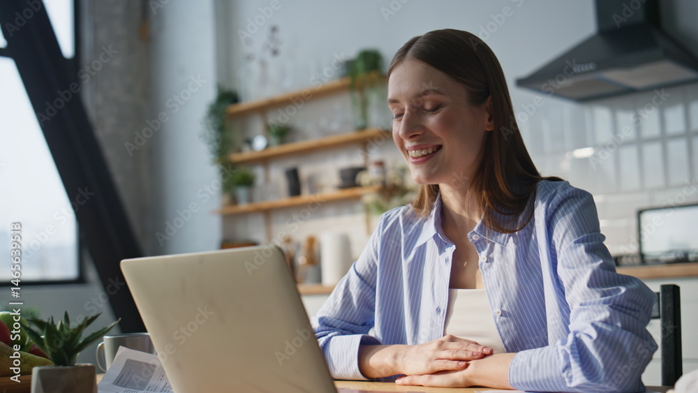 Successful entrepreneur talking video meeting by laptop at home kitchen closeup